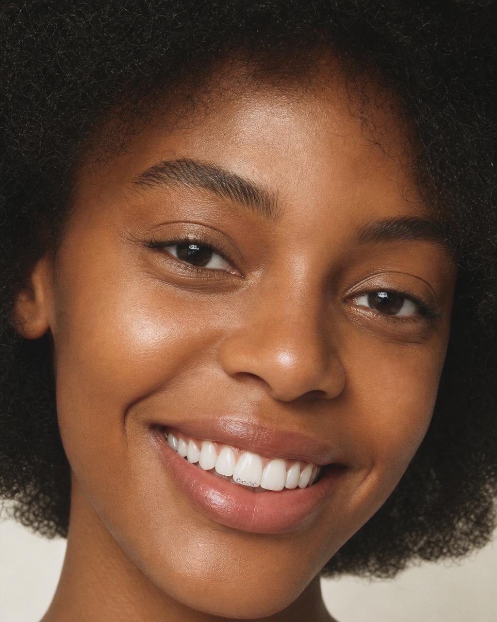 Lächelnde Frau mit Afrohaaren und funkelndem Tooth Gem